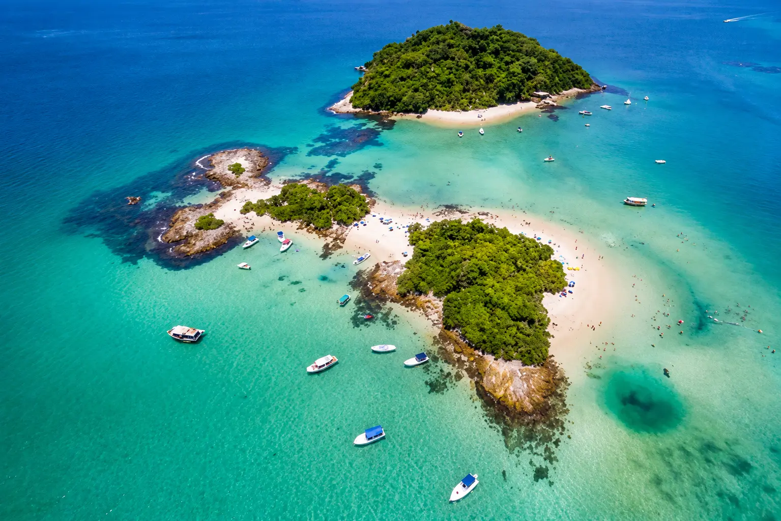 Boats anchored over the sandbar between two islands