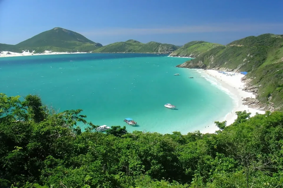 White sand and cold clear water under green headlands