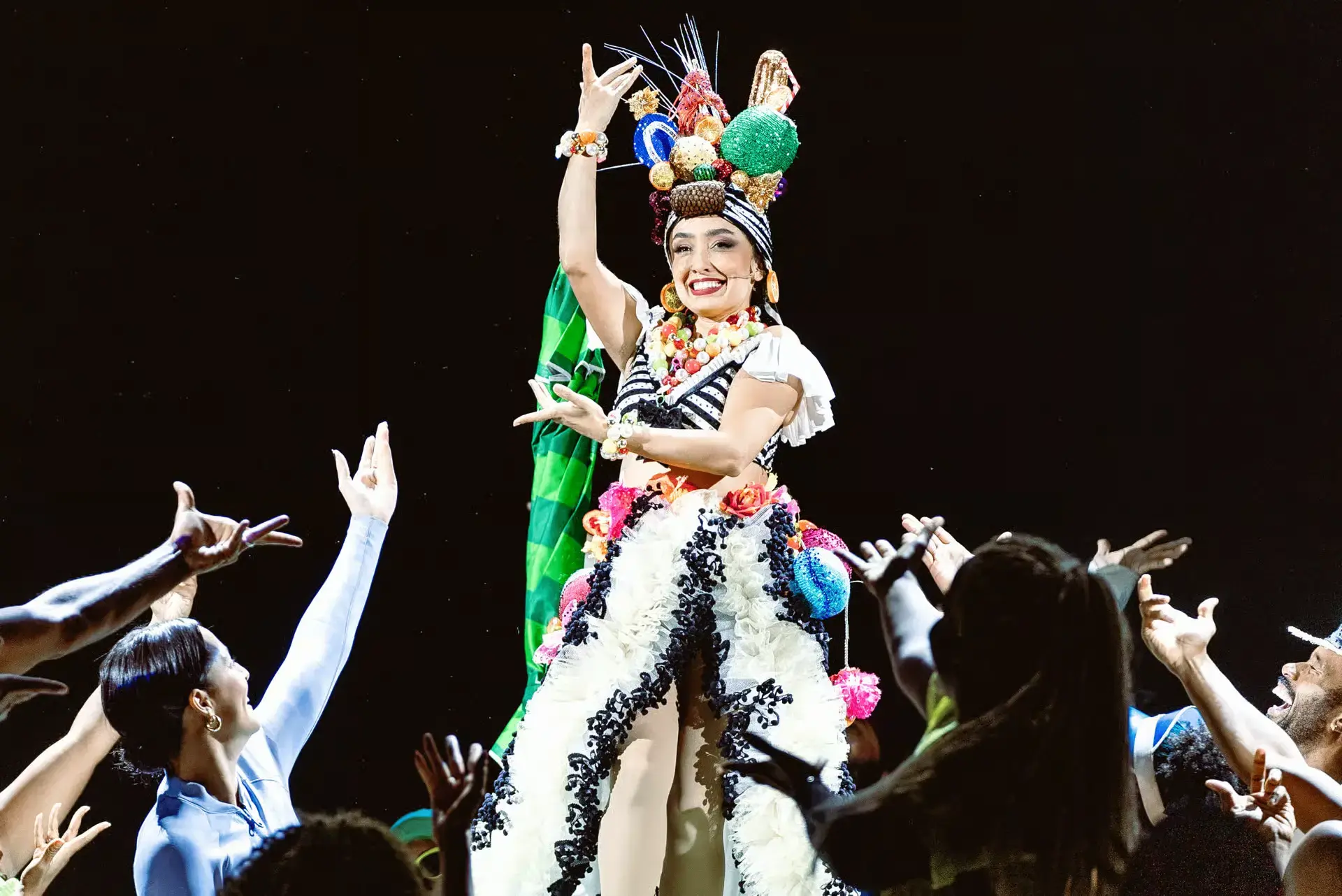 Fruit piled on a headdress, and the whole stage below