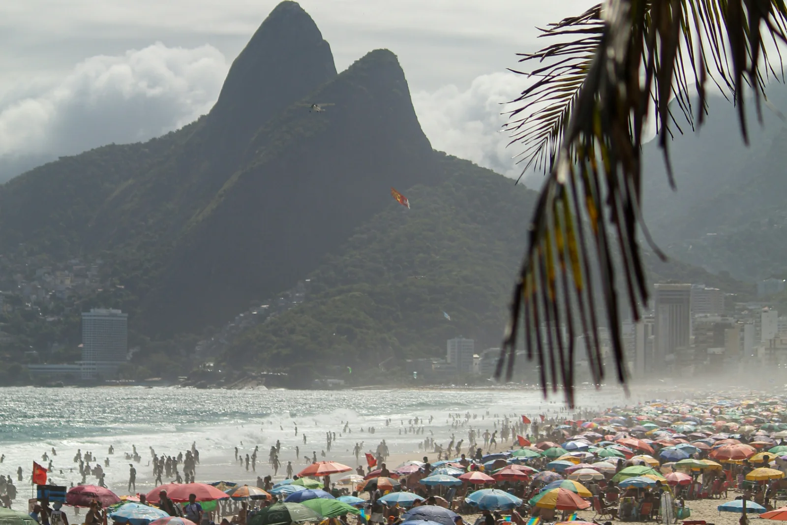 Ipanema beach looking west to the twin peaks of Dois Irmaos, the Leblon buildings at their foot and the sand full of umbrellas