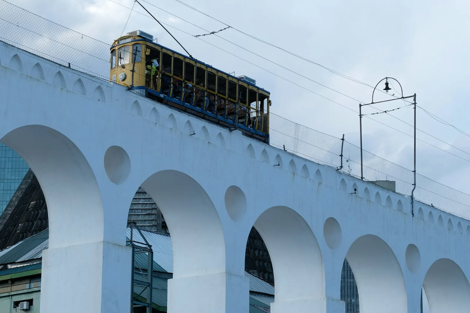 The Lapa arches in Rio, a yellow Santa Teresa tram crossing the top of the aqueduct