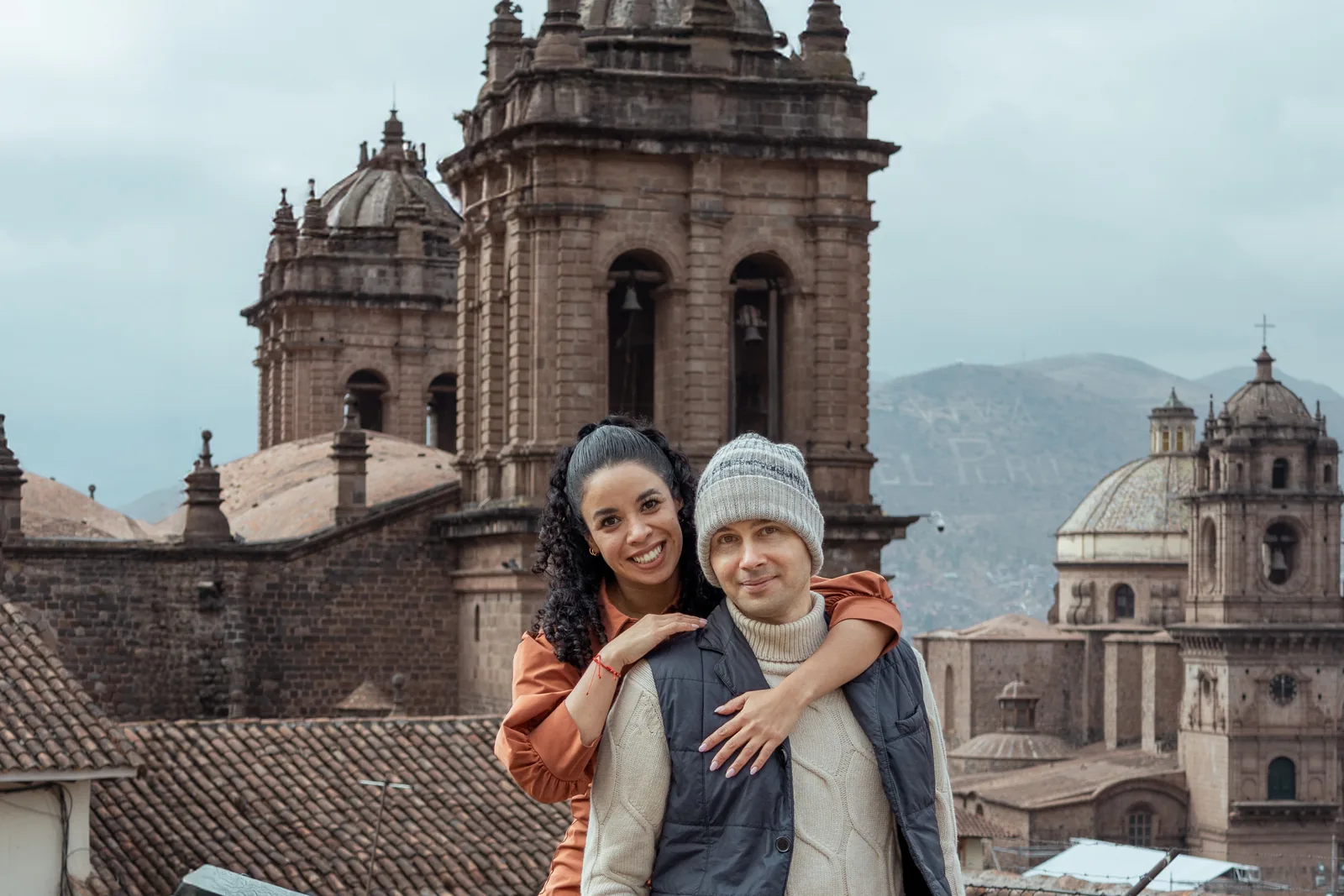 Melissa and Aleksejs on a terrace above Cusco, with the cathedral towers and tiled roofs behind them
