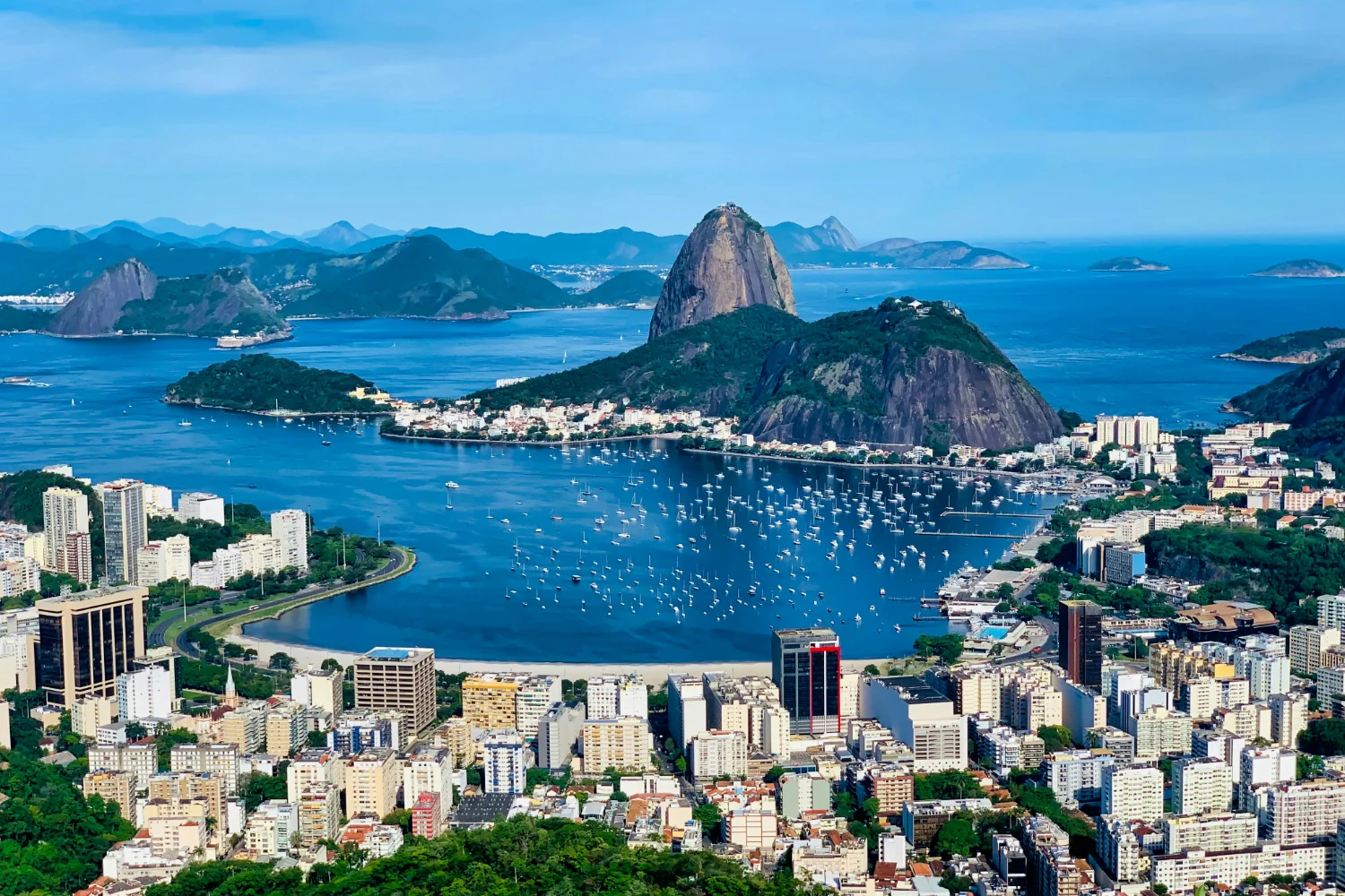 Pão de Açúcar a la entrada de la bahía a plena luz del día, con barcos amarrados en Botafogo y los techos de la ciudad a sus pies