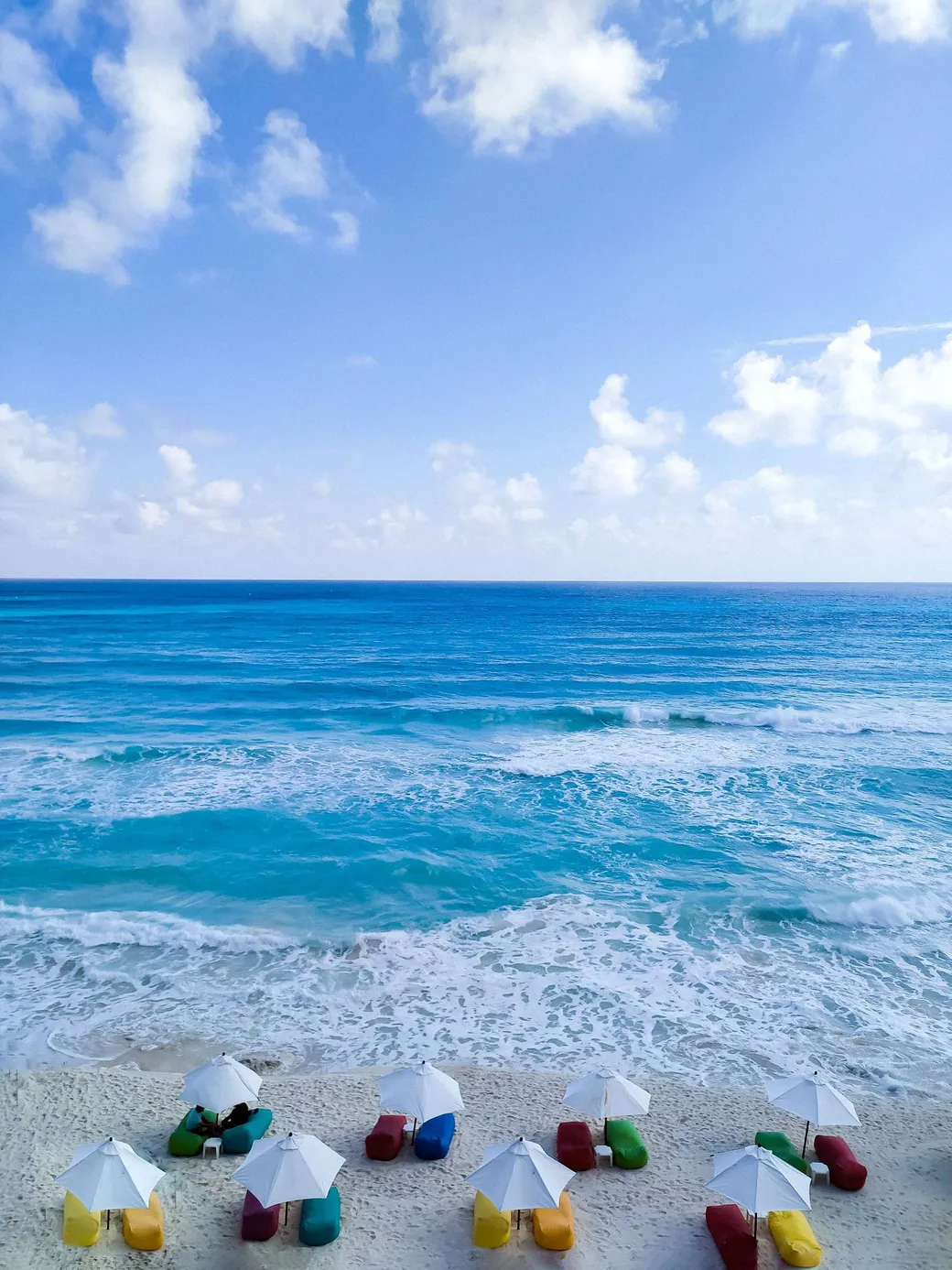 Umbrellas and beanbags on a Cancún beach, seen from above