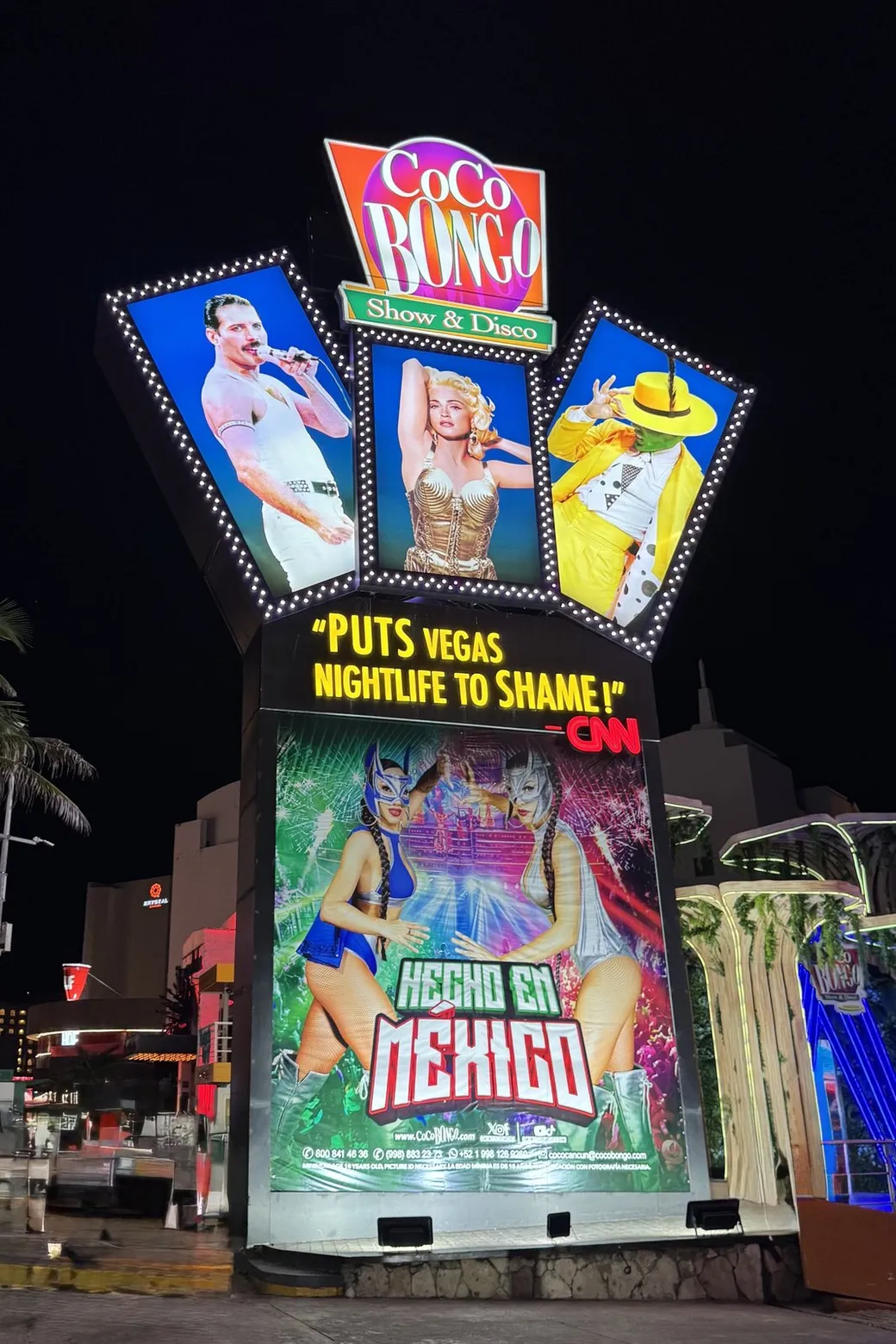 The Coco Bongo sign lit up over the street at night