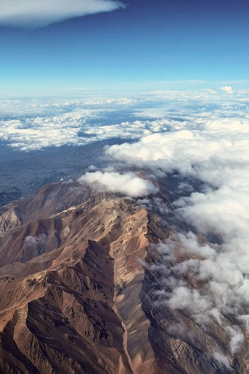 Bare ridges breaking through the cloud, seen from the air