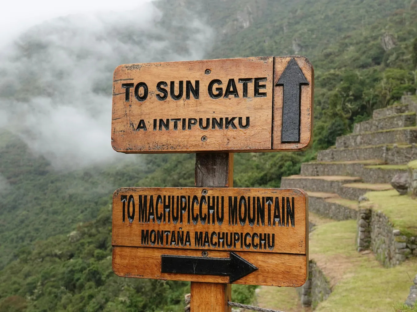 A trail sign at Machu Picchu: the Sun Gate ahead, Machu Picchu Mountain to the right