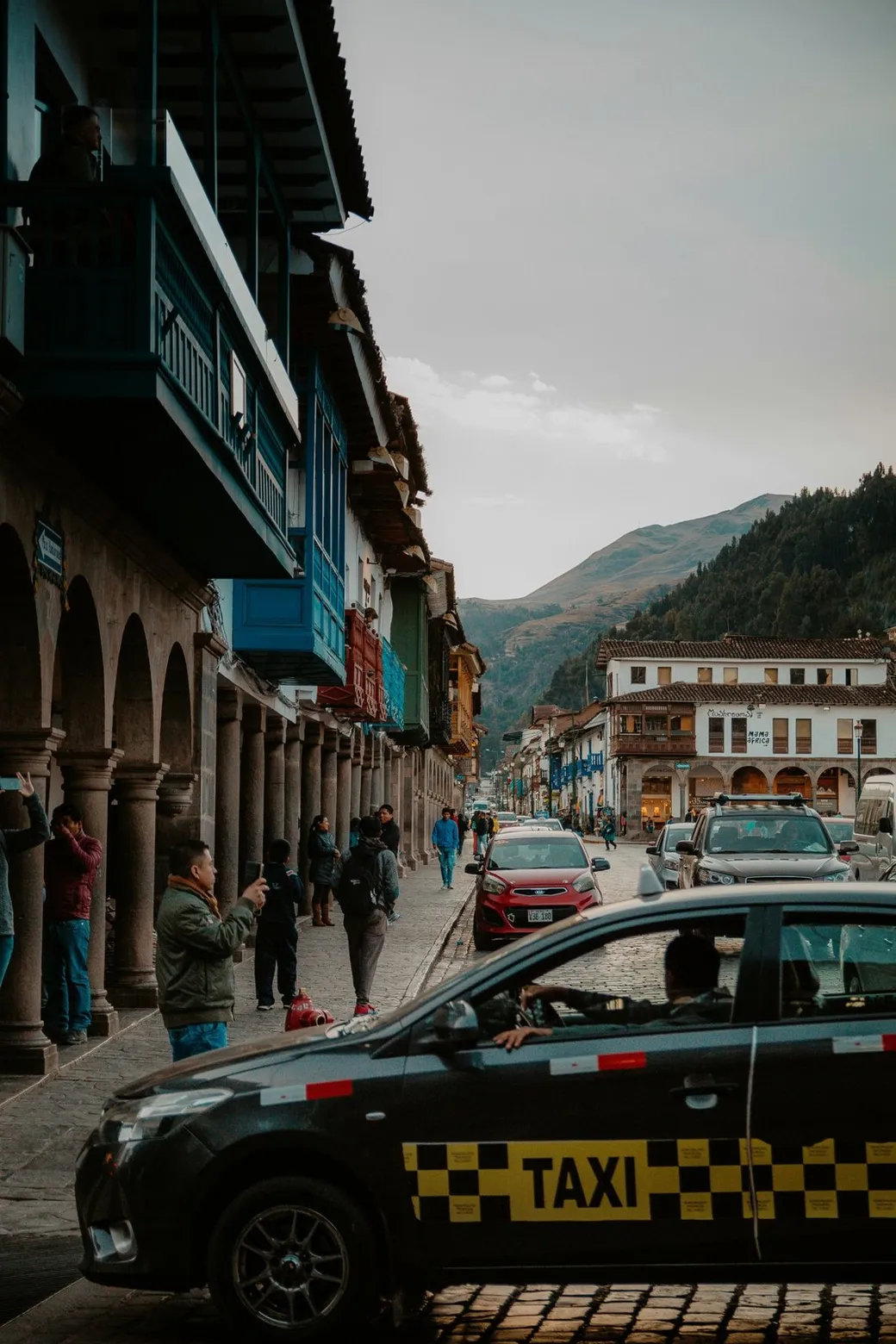 A taxi below a row of wooden balconies