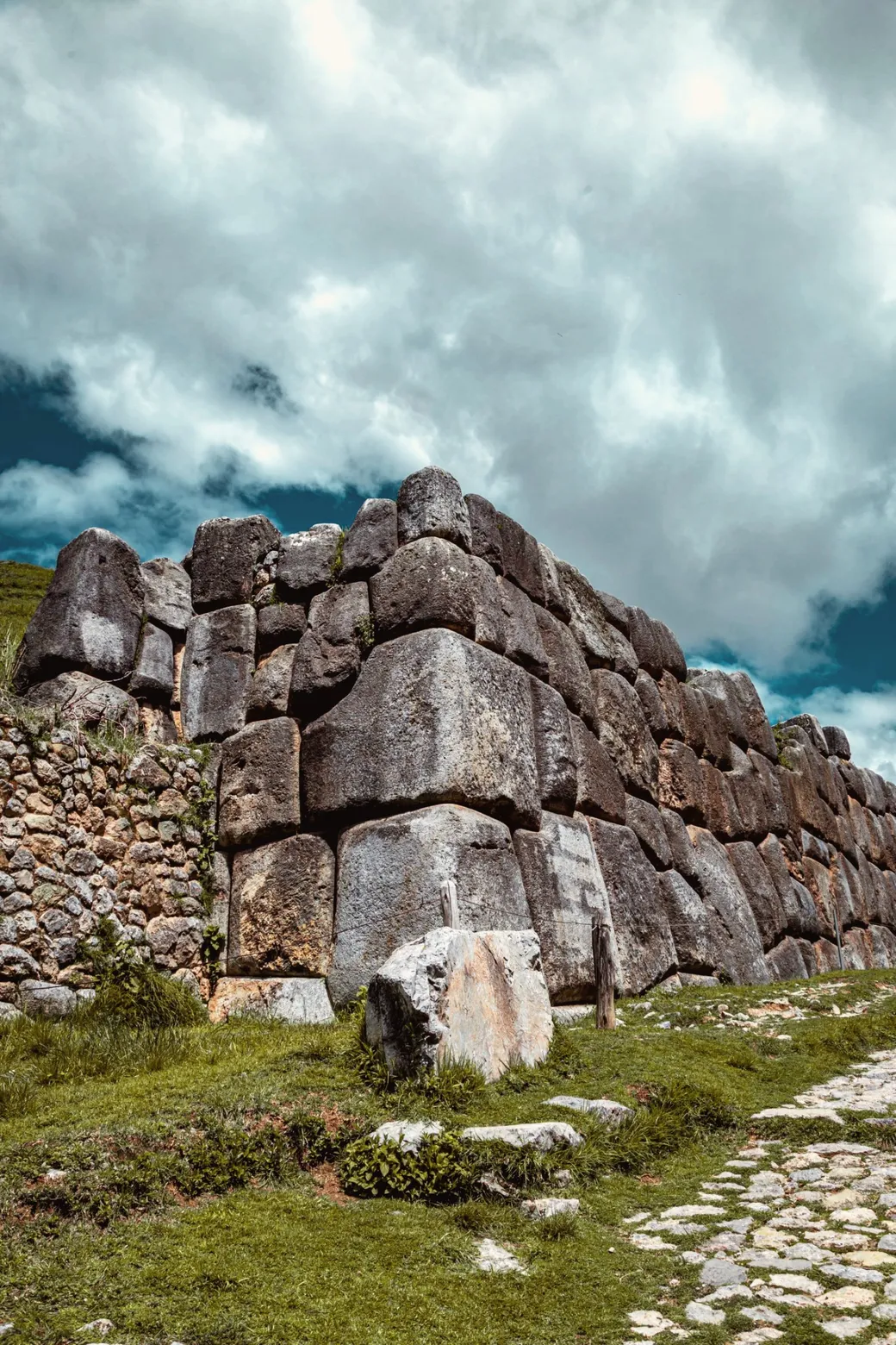 Great fitted stones of an Inca wall under heavy clouds