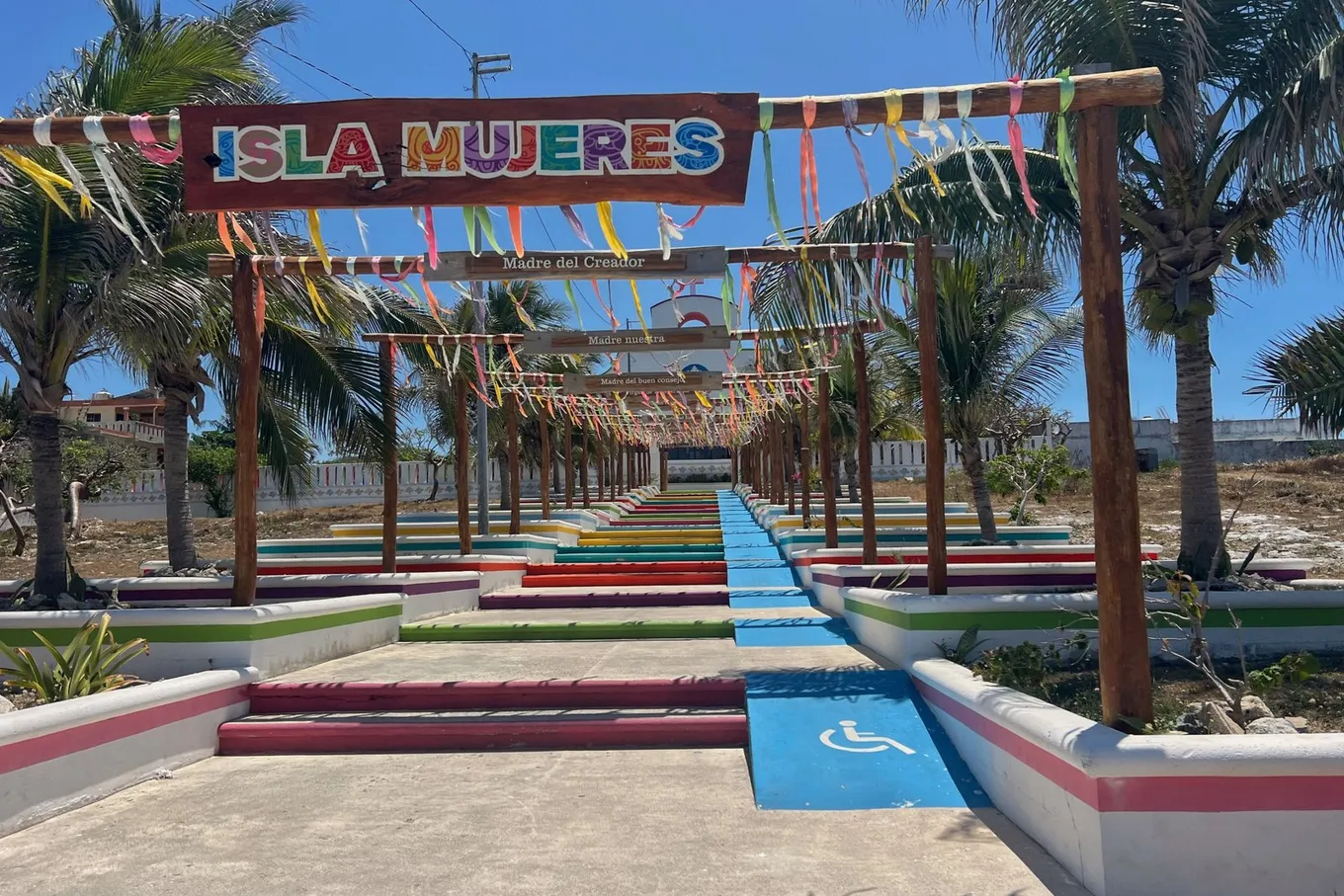 A painted ISLA MUJERES sign over colored steps and ribbons