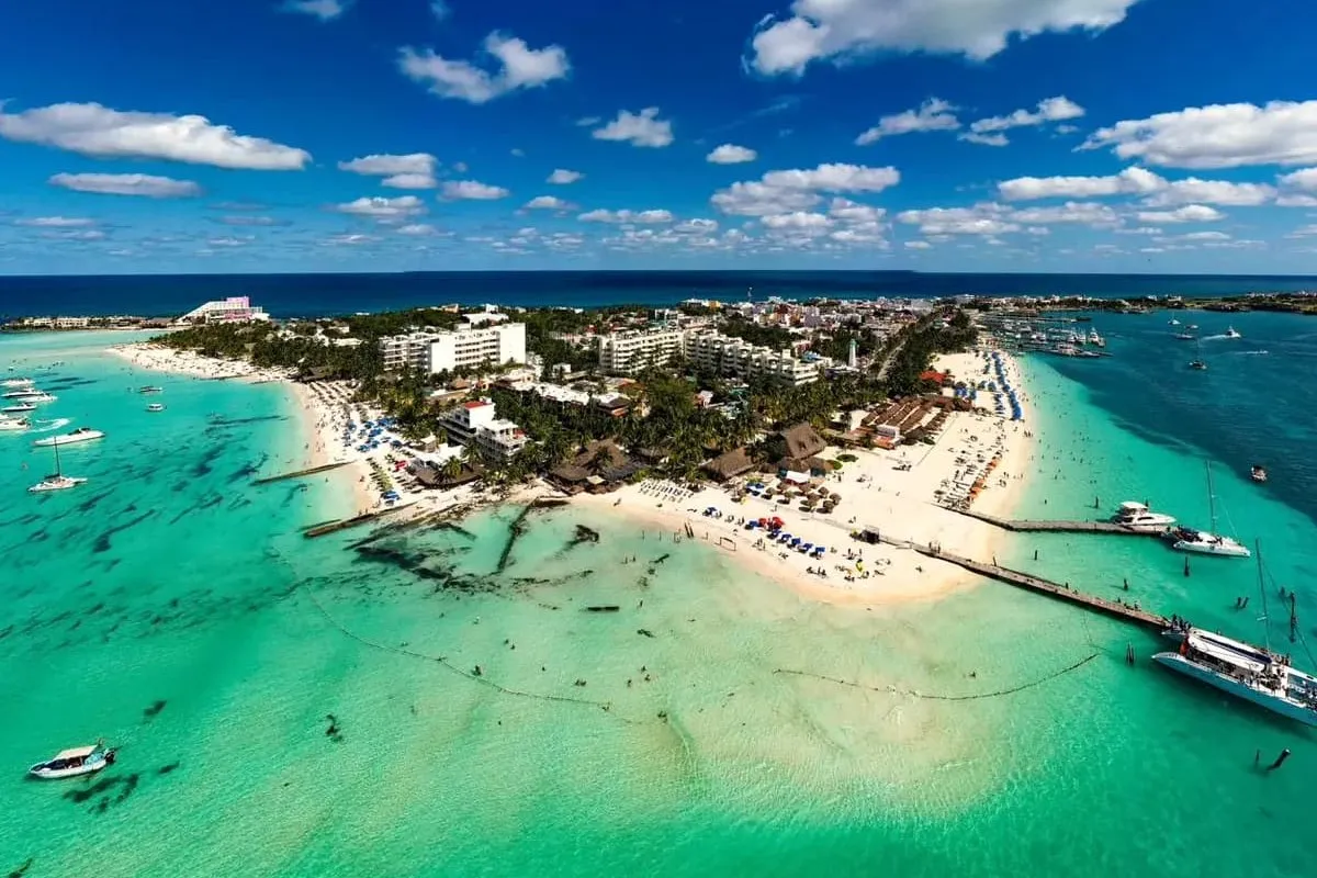 A sandy tip of the island, boats moored off its piers
