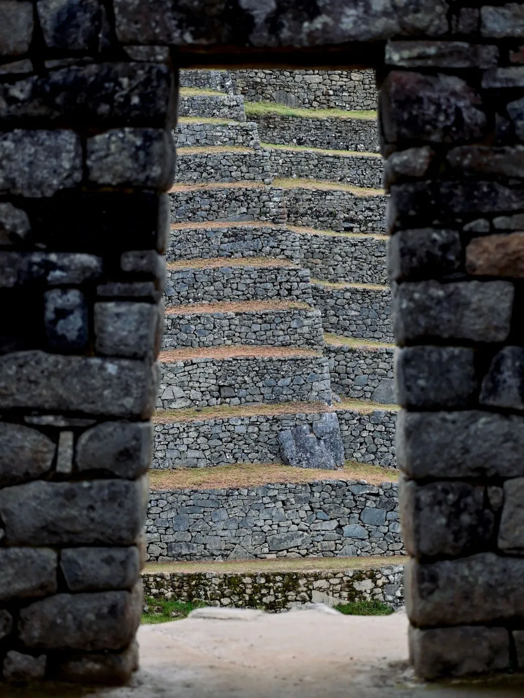 Inca terraces seen through a stone doorway