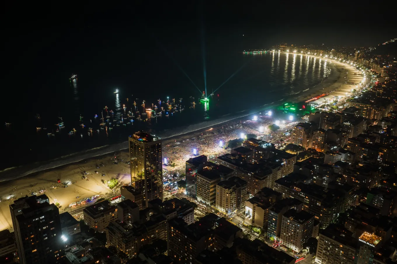 Copacabana à noite, uma multidão na areia diante de um palco iluminado
