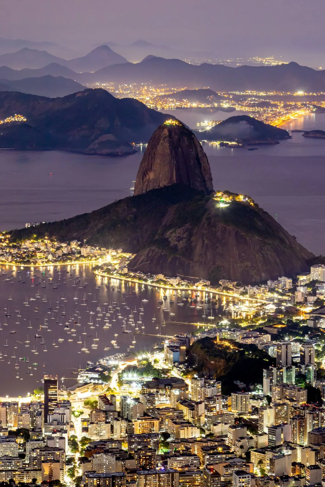 Sugarloaf above Botafogo Bay at night, the boats and the shore lit below