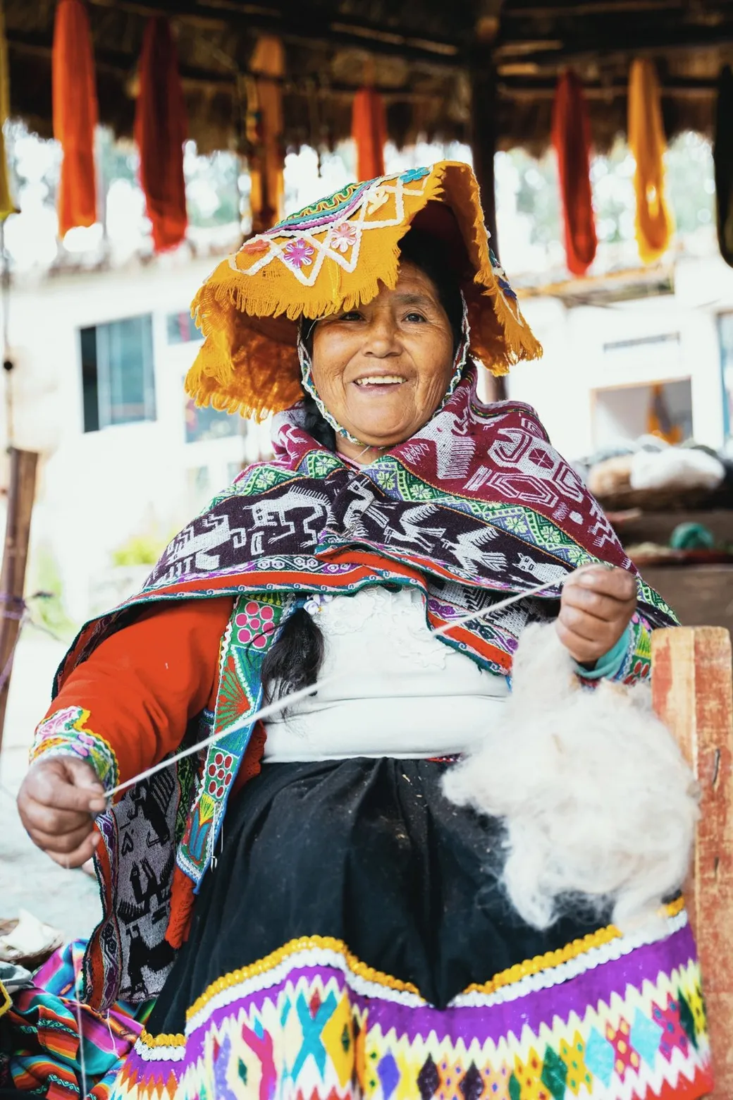 A weaver spinning white fleece by hand