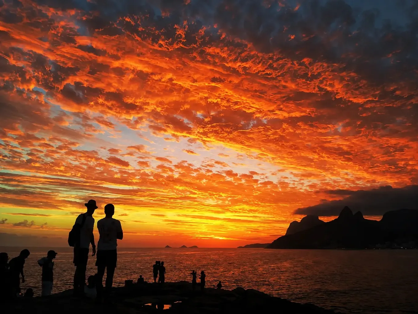 Sunset crowd on the rock, Dois Irmãos dark against the sky