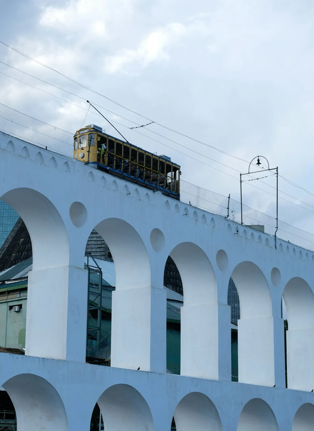 The yellow tram crossing the white arches