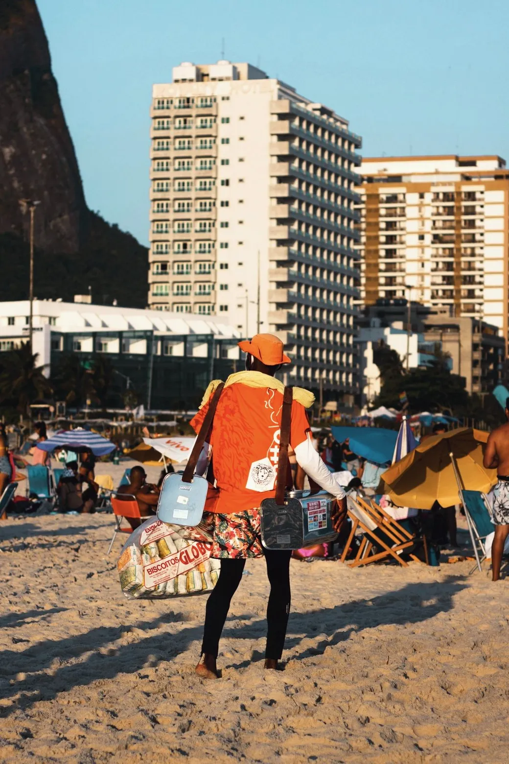 A beach vendor with a sack of Biscoito Globo and two tanks