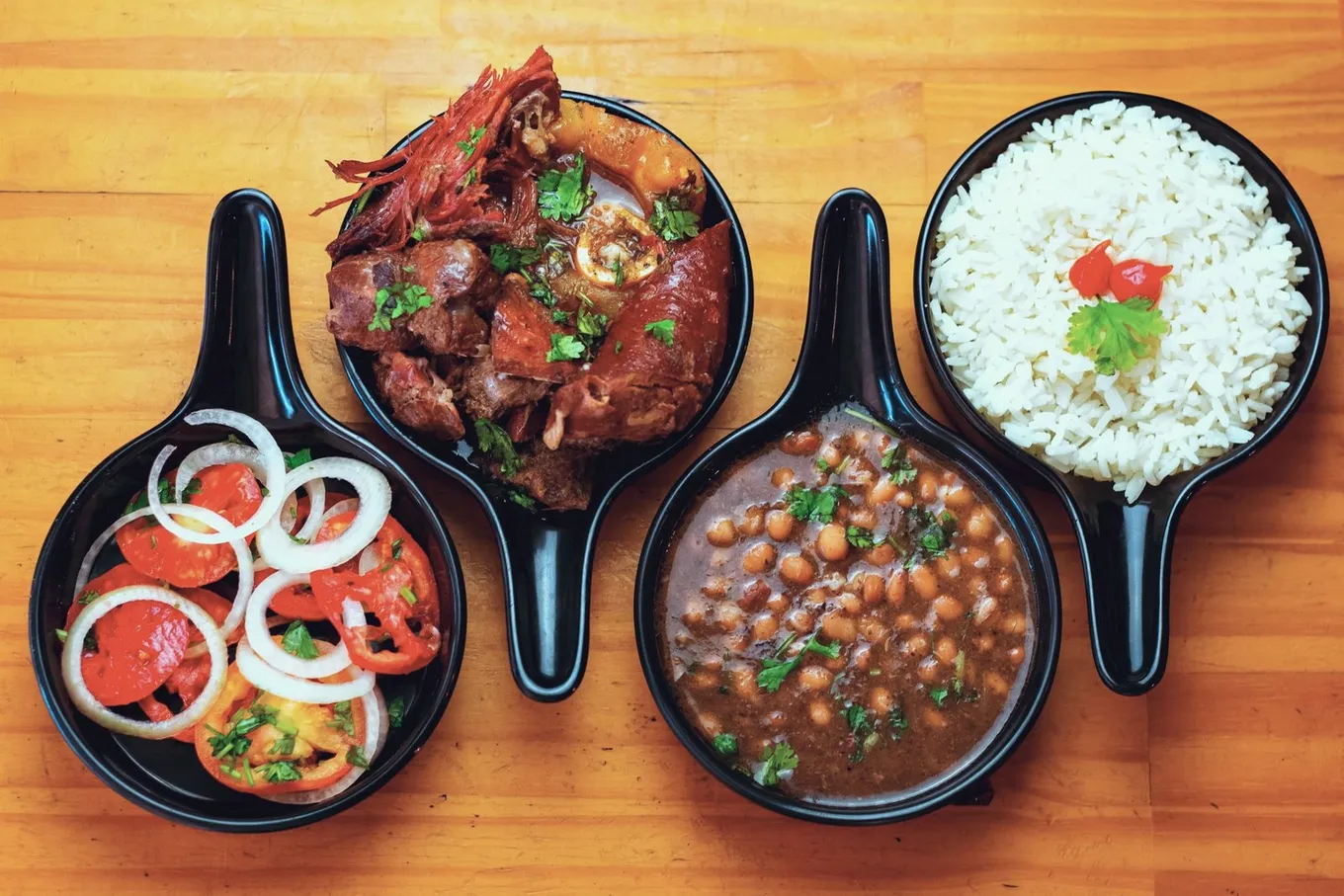 Beef, beans, rice, and an onion salad in four dishes