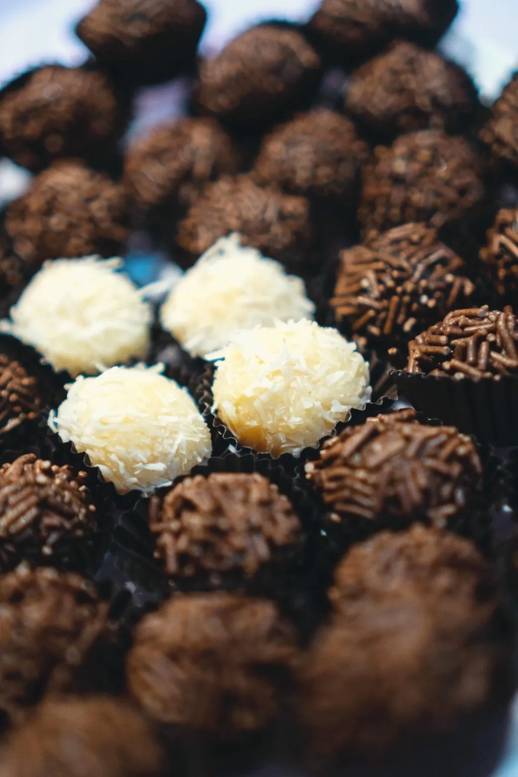 Brigadeiros and white coconut beijinhos, side by side