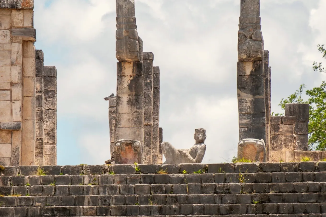 Stone columns and a Chac Mool figure at the top of the Temple of the Warriors