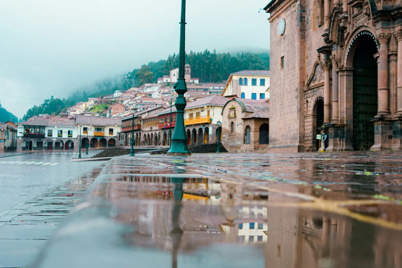 The Plaza de Armas in Cusco after rain, under low cloud