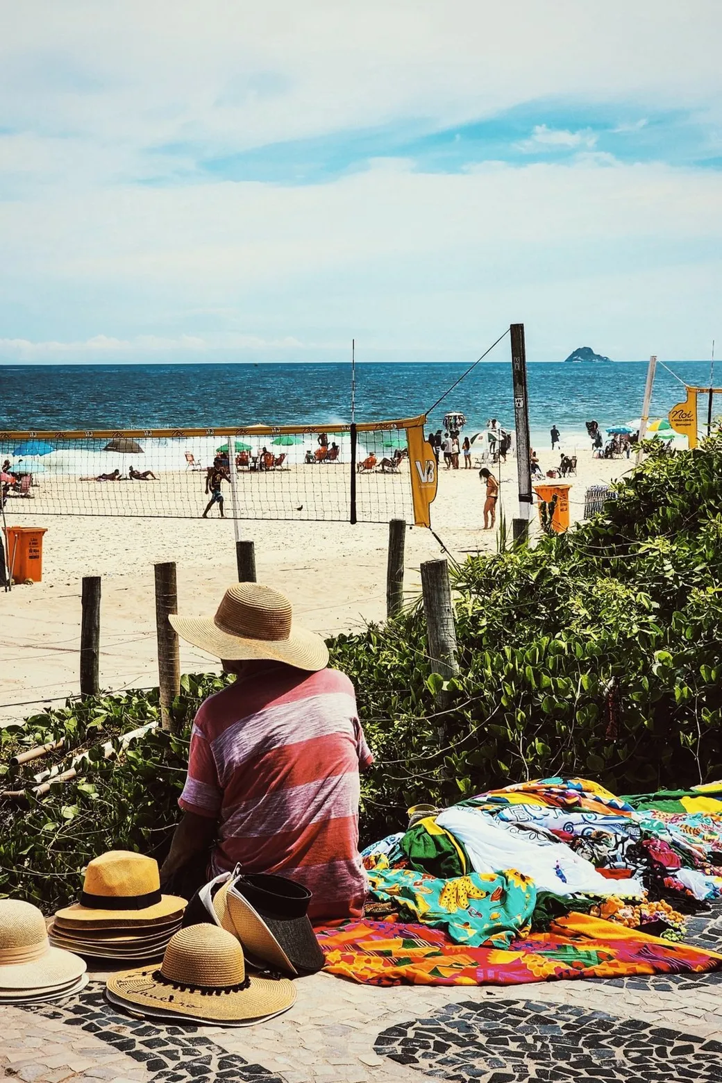 Straw hats and cangas spread out beside the sand