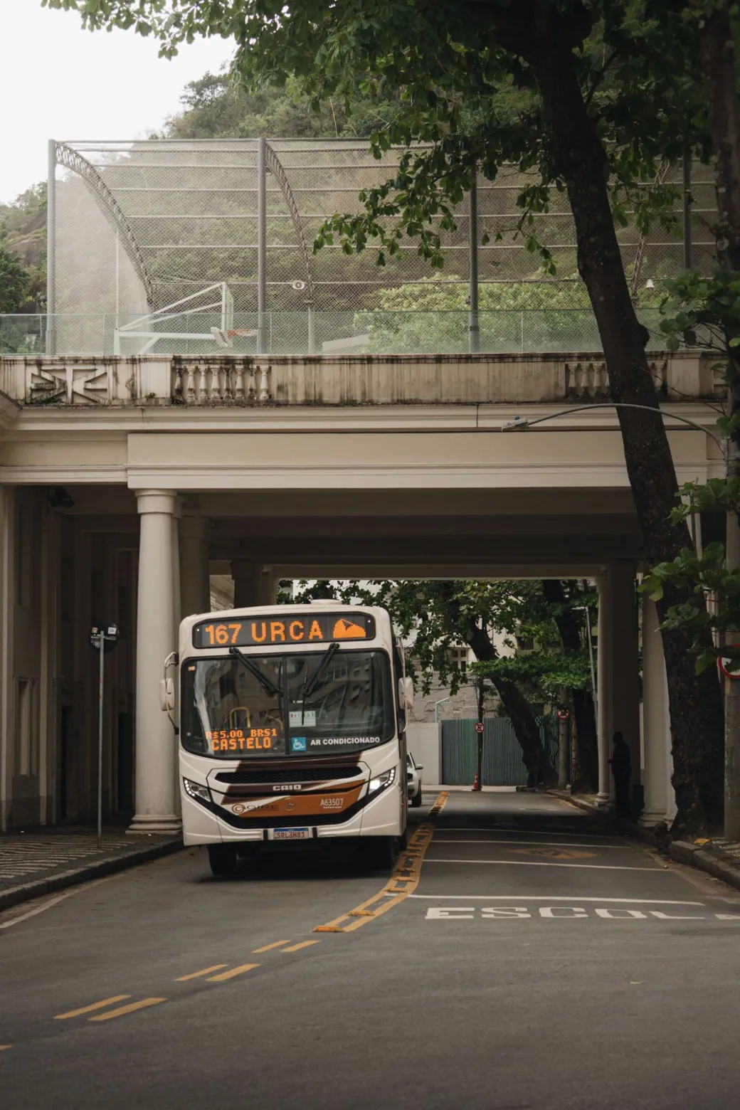 A city bus marked 167 Urca under a colonnade, trees on either side