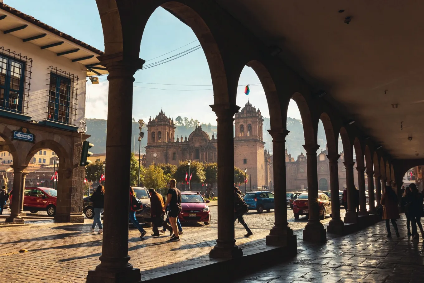 The cathedral seen through a colonial arcade · Cusco, Peru