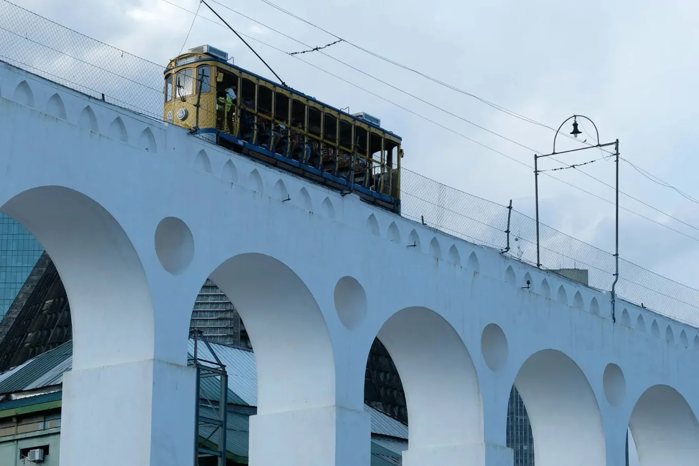 The yellow tram crossing the white arches at Lapa